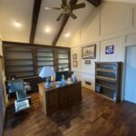 Interior view of a remodeled living room with wooden beams and a ceiling fan